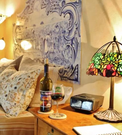 Wine and lamp on bedside table inside Blue Sky Vineyard Suite.
