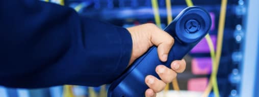 Hand holding a phone representing The Benefits of Hosted VoIP for Businesses