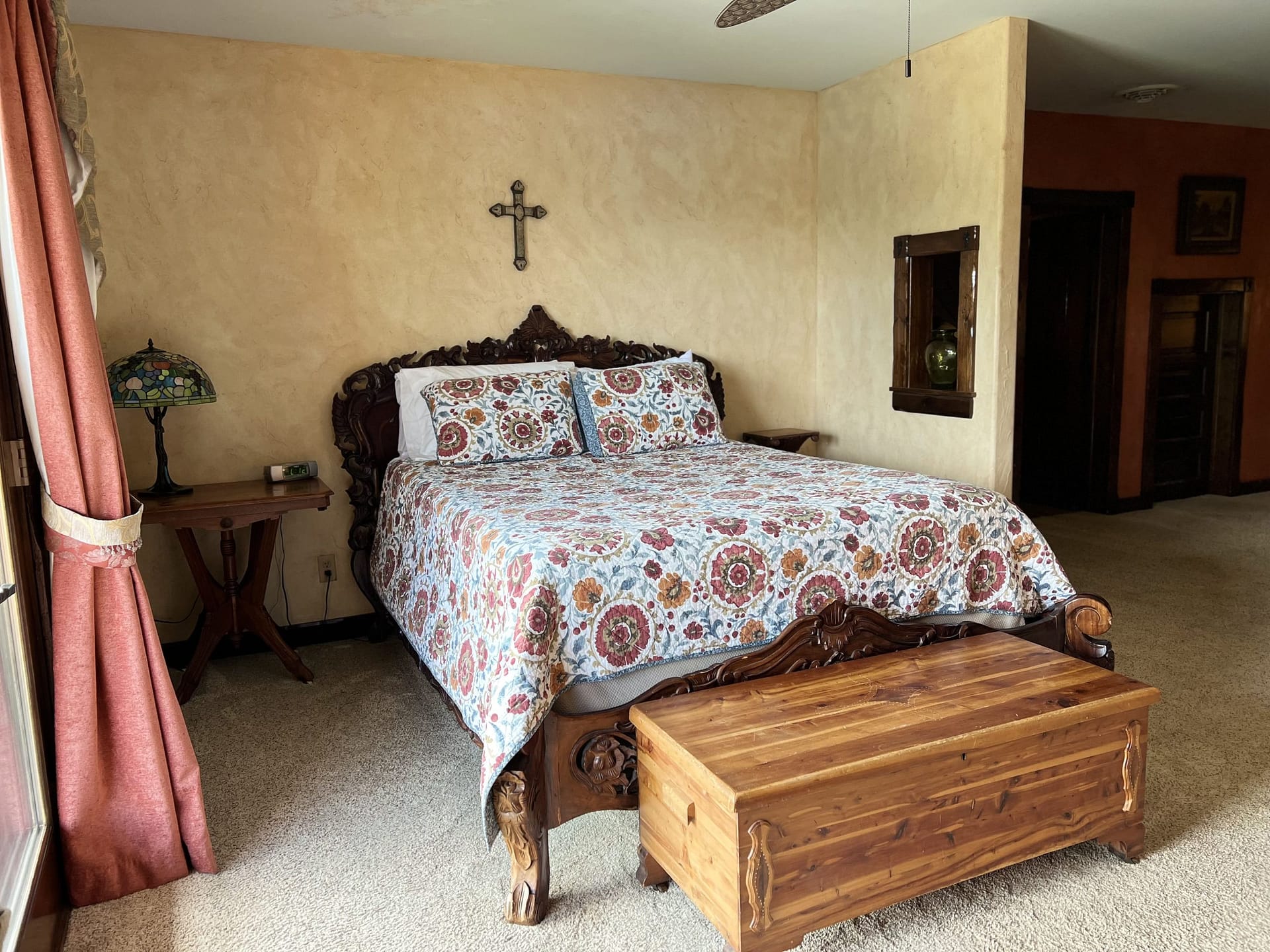 Spacious Tuscan-inspired room at Blue Sky Vineyard with carved wooden bed.