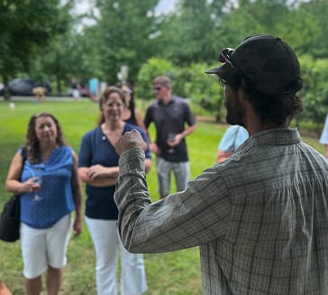 Tour guide speaking to visitors during a vineyard tour at Blue Sky Vineyard.