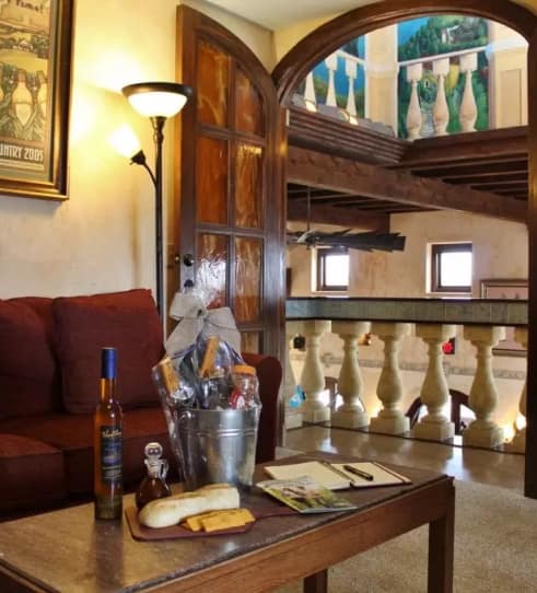 Interior of Tuscany Romance Suite with wine and gourmet basket.